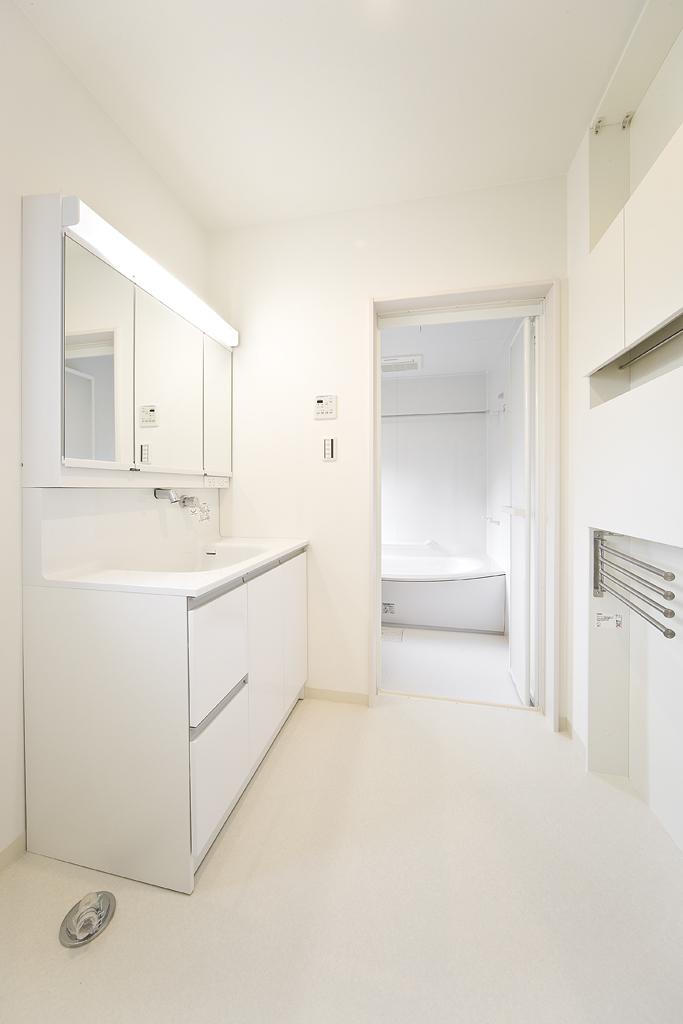 Bathroom. Basin and bathroom accentuate white keynote cleanliness and brightness. Towel rack and linen cabinet is functional and in design to be cleaner (model house)