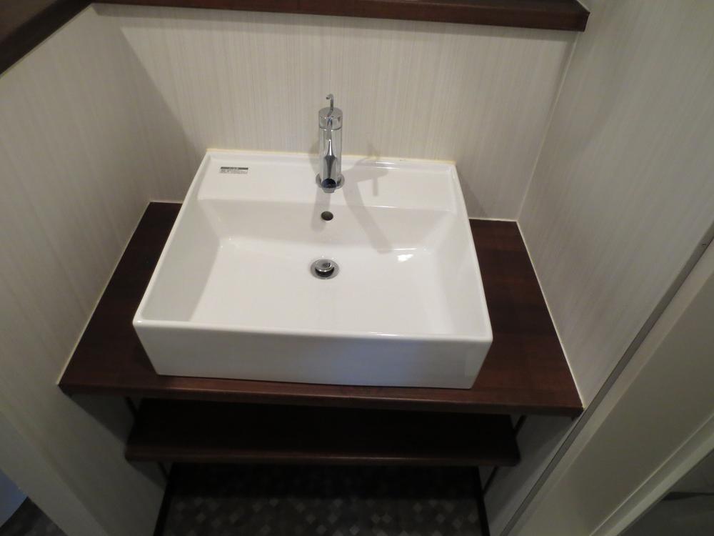 Wash basin, toilet. It is the washroom.