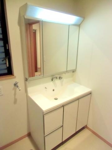 Wash basin, toilet. Storage is abundant and convenient three-sided mirror