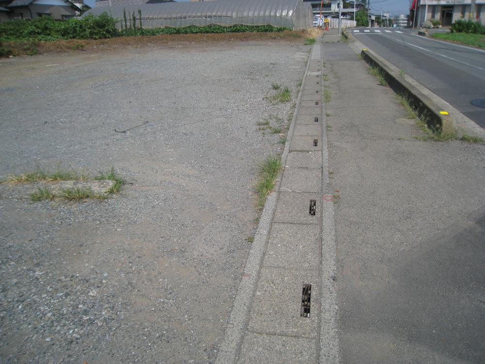 Local land photo. It is a sidewalk and gutter. 