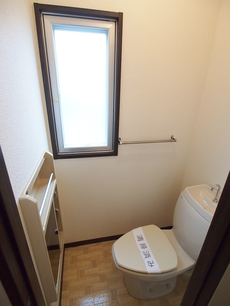 Toilet. Small window with bright toilet