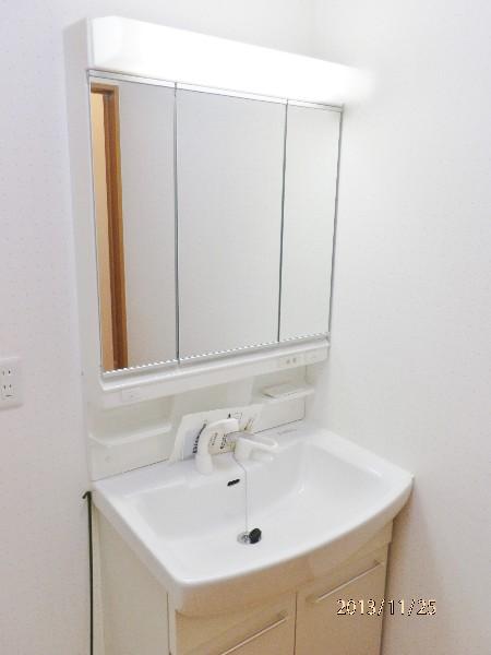 Wash basin, toilet. It is a three-sided mirror dresser with a shower head!