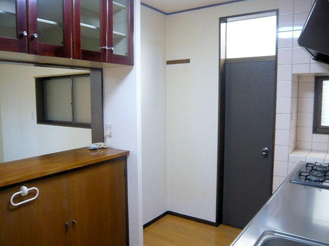 Kitchen. Cupboard hanging directly behind the kitchen, Beyond that is the living.