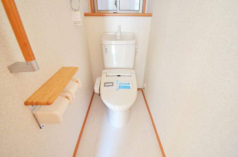 Toilet. Toilet equipped with a handrail