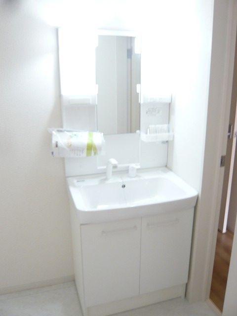 Wash basin, toilet. White shampoo dresser. Behind the Mirror has become the storage.