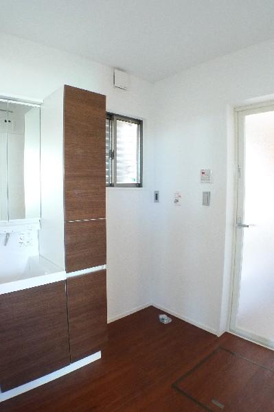 Wash basin, toilet. Wash room with storage shelves and wide type of dresser. 