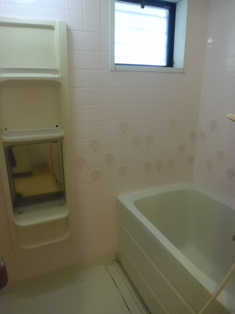 Bath. Bathroom with small window. Shampoo rack is also located convenient.