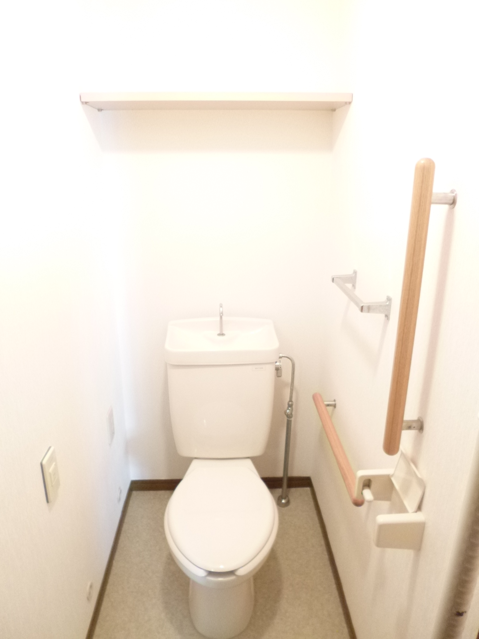 Toilet. Spacious toilet with a shelf.