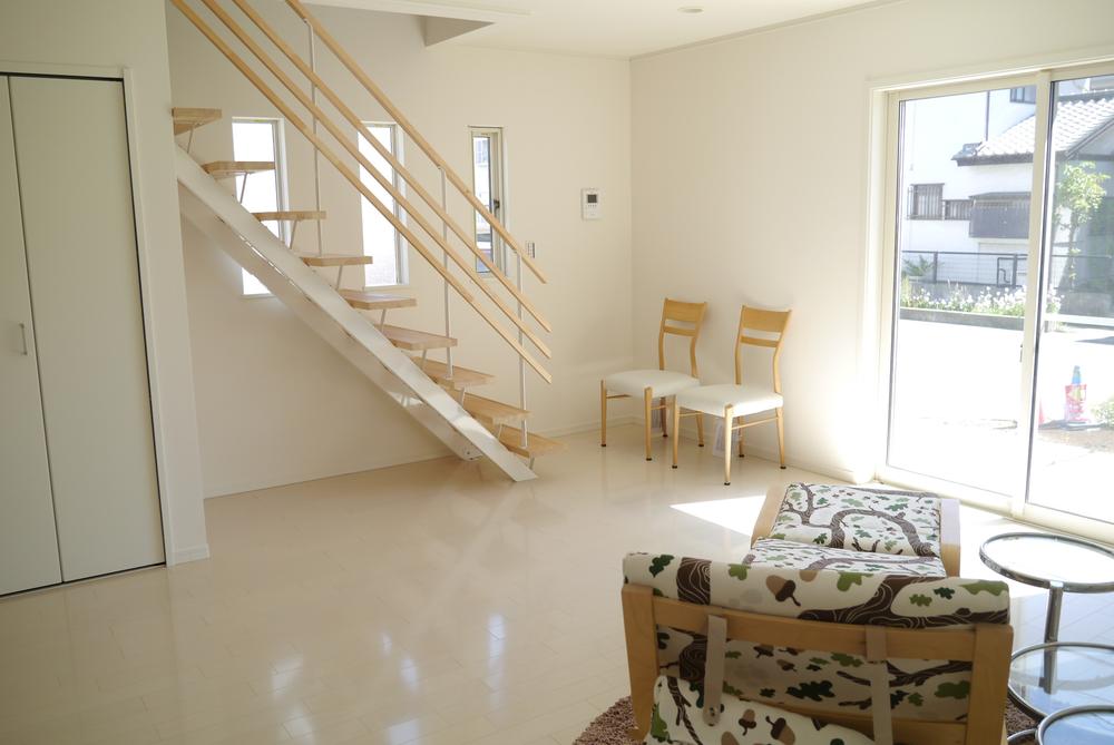 Living. Family will create a place to match sure to face in the living room stairs. It is bright with white flooring. 