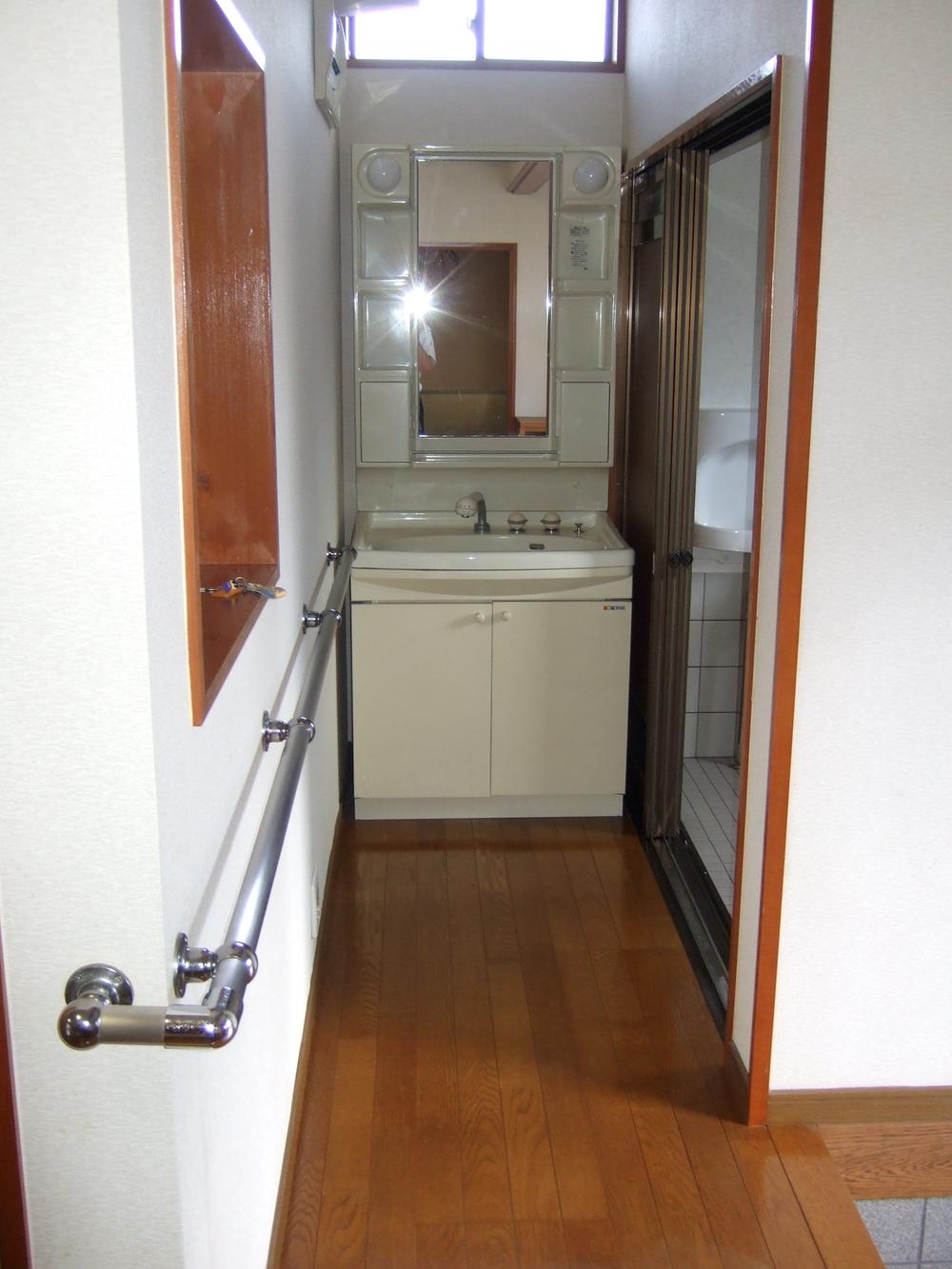 Wash basin, toilet. Washbasin with shower, Handrail is attached to the corridor