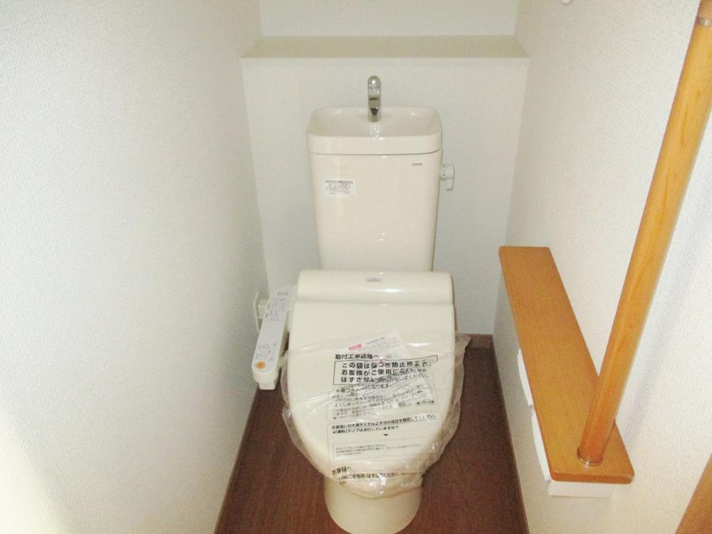 Toilet. Toilet with a handrail