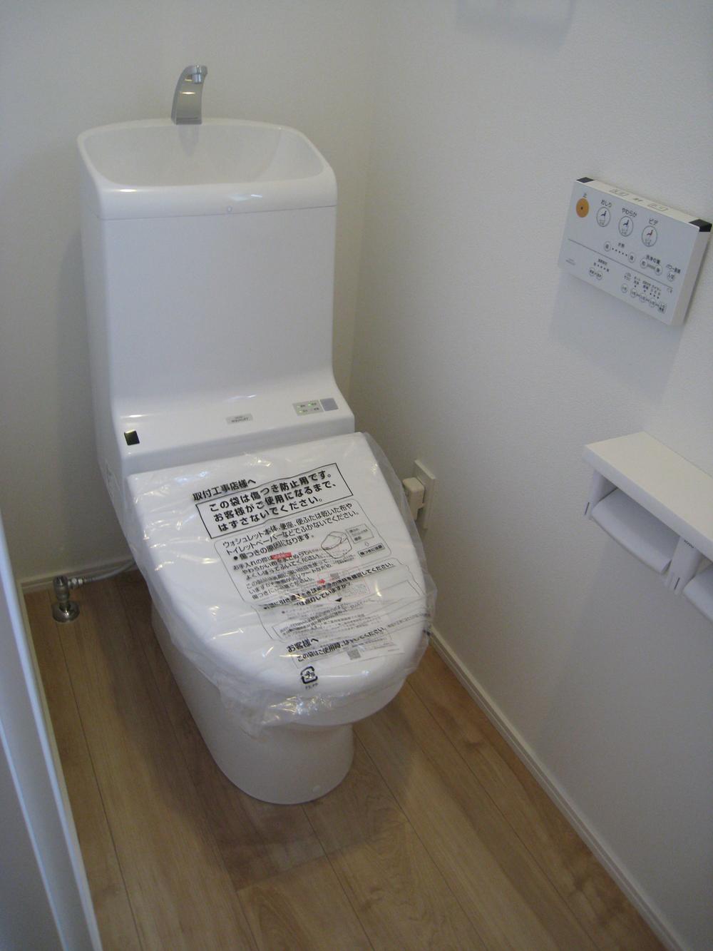 Toilet. First floor toilet is equipped with cleaning toilet seat. 