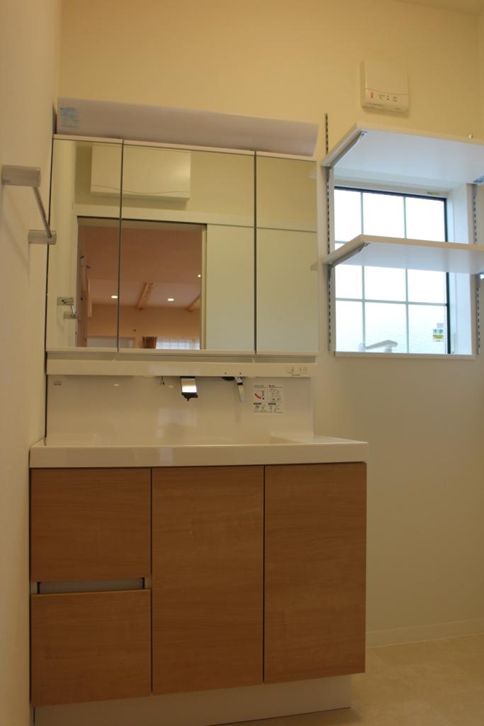 Wash basin, toilet. Wash basin is three-sided mirror. Also with shelves movable on top of the washing machine