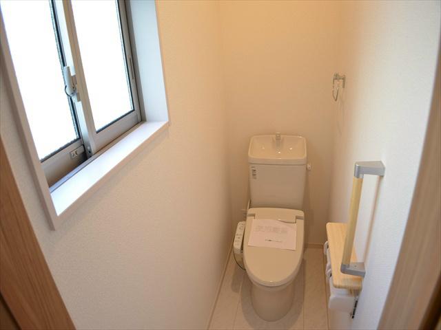 Toilet. Toilet with a handrail