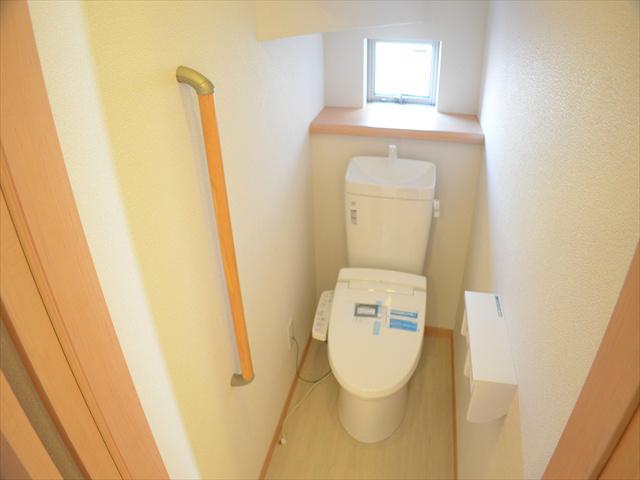 Toilet. Toilet with a handrail
