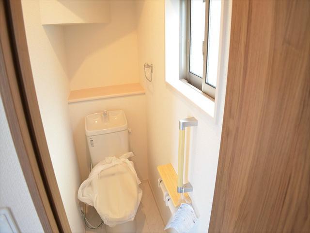 Toilet. Toilet with a handrail