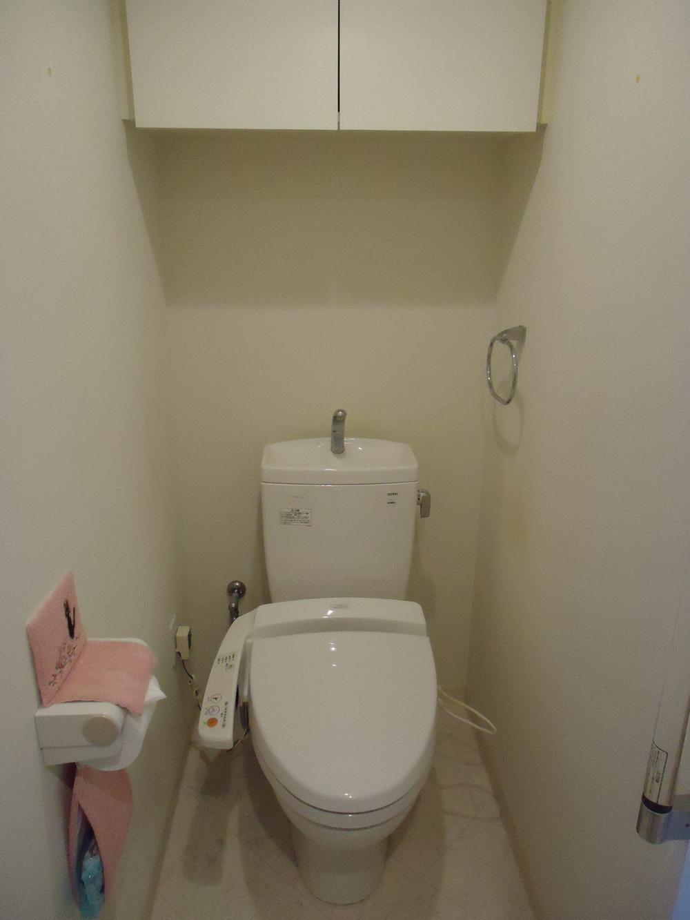 Toilet. There cupboard hanging on the top