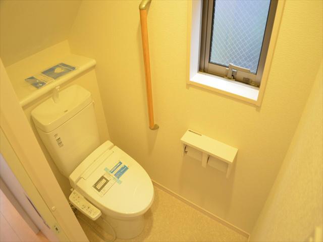 Toilet. Toilet with a handrail