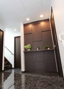 Entrance. Example of construction. Entrance hall with marble and brown makeup wall of marble is to produce a profound feeling of luxury