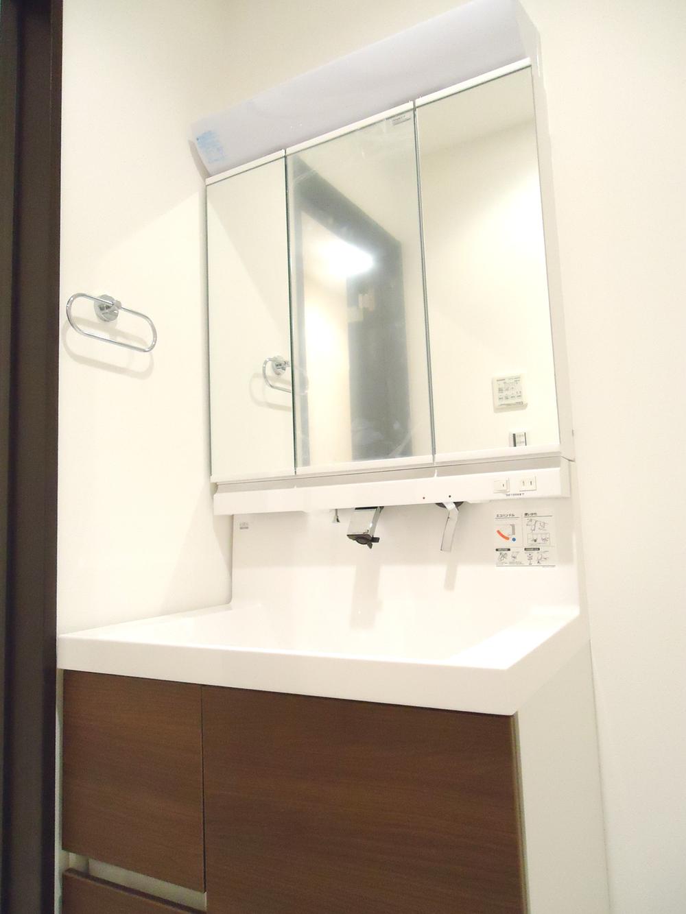 Wash basin, toilet. Large three-sided mirror vanity. Storage is also abundant. 