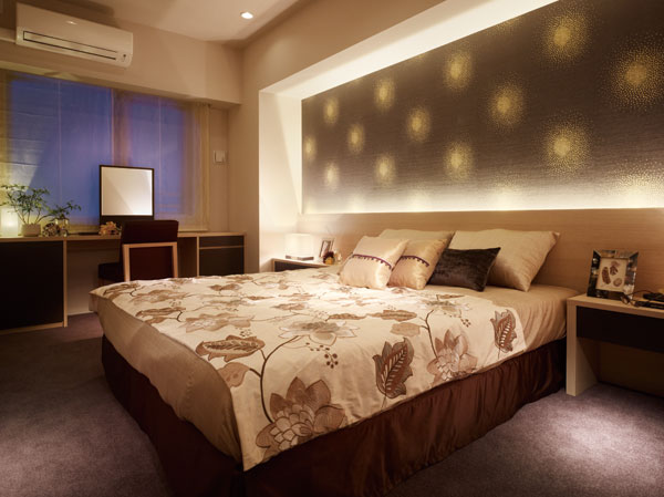 Interior.  [Western-style 1] Accent cross decorated with impressive textile, Bed throw of floral. It has directed the space of deep peace and heavy use of indirect lighting. Furniture of dark brown has full of texture after having settled down to beige keynote.