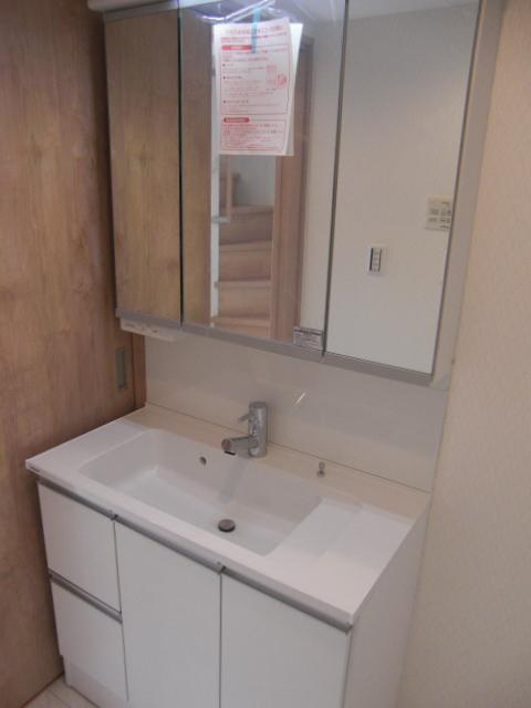 Wash basin, toilet. Three-sided mirror is with storage washroom.