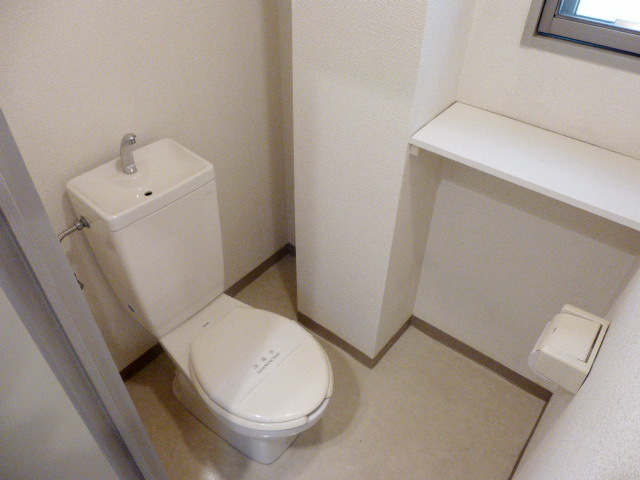 Toilet. There are shelves and a window in the toilet