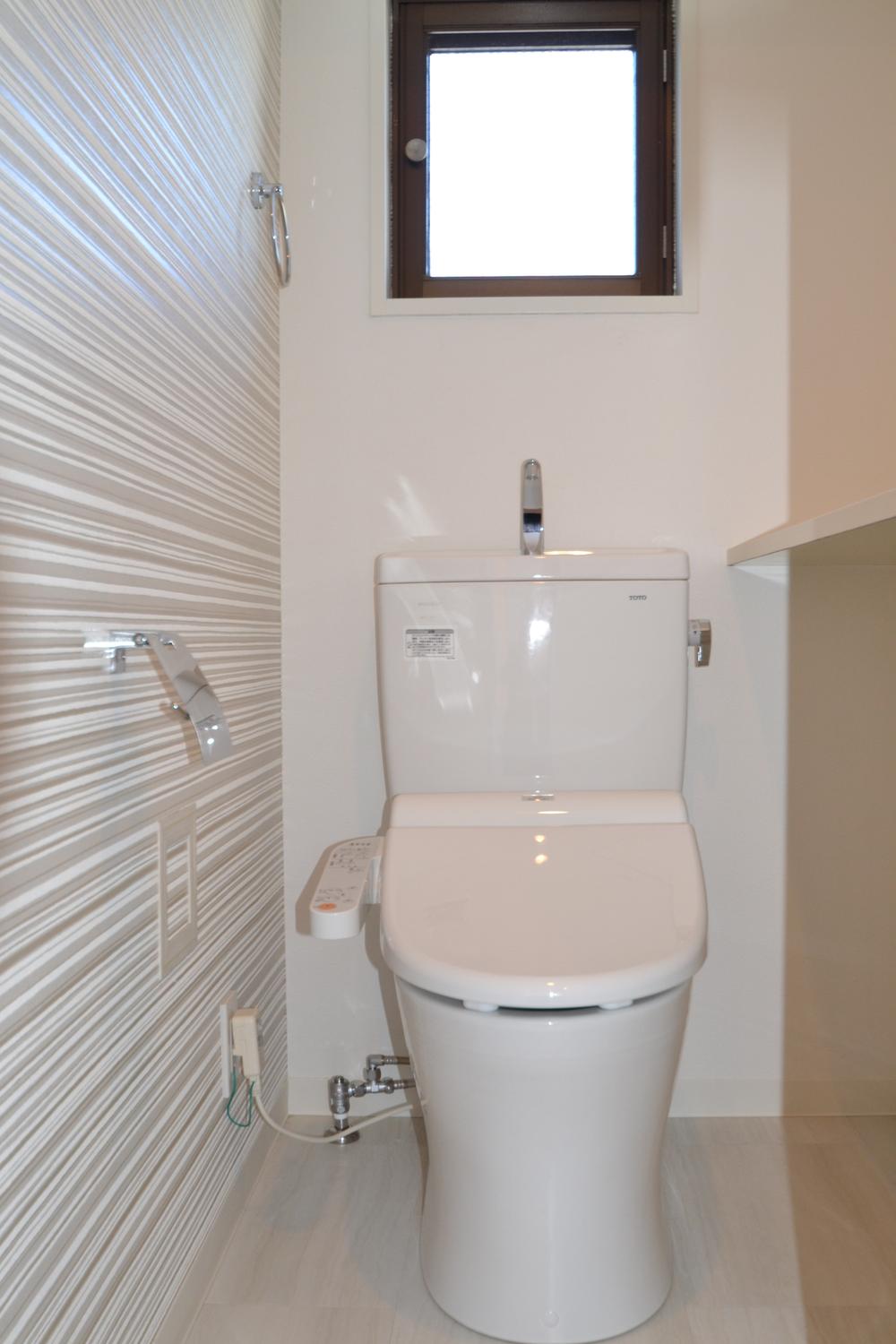 Toilet. With window. With counter. Bathroom with a shower.