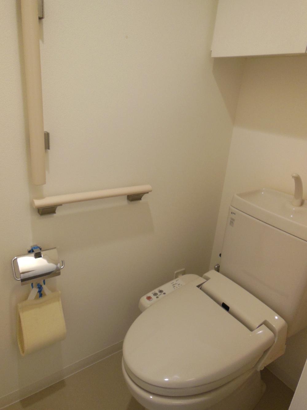 Toilet. Back storage, L-type handrail, Warm water cleaning toilet seat is provided