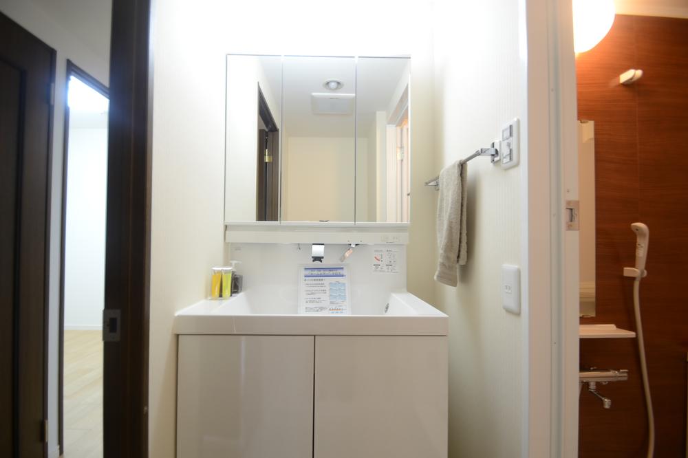 Wash basin, toilet. Three-sided mirror with vanity