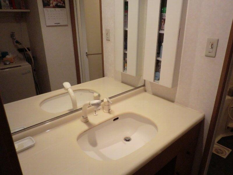 Wash basin, toilet. Wash basin with a large mirror and shower faucet.
