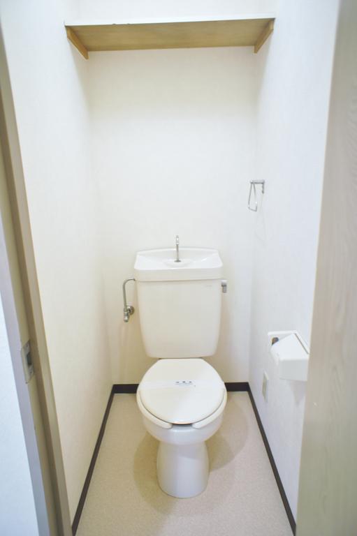 Toilet. There is storage rack at the top