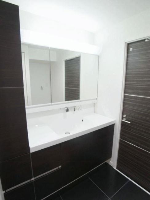 Wash basin, toilet. Vanity with a wide mirror