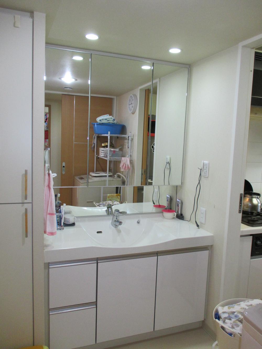 Wash basin, toilet. The washroom has a three-sided mirror, Storage is abundant.