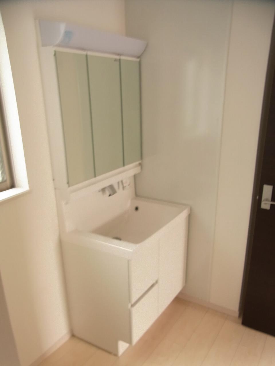 Wash basin, toilet. Vanity is three-sided mirror type