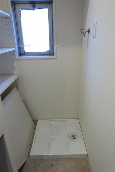 Wash basin, toilet. There is a window is bright wash room