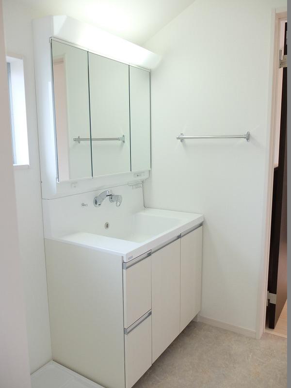 Wash basin, toilet. Vanity is three-sided mirror type