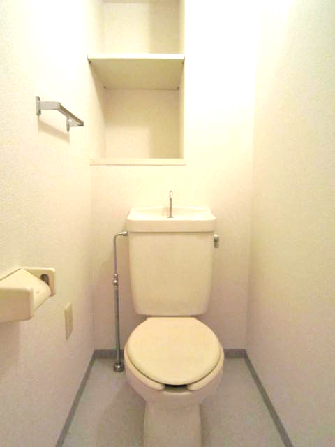 Toilet. Toilet with a storage rack, Yes outlet.