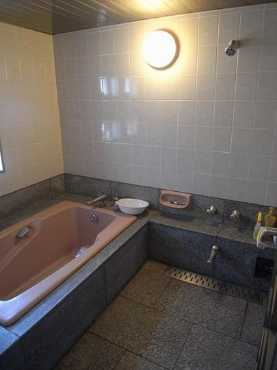 Bathroom. Large bathtub made of is in the bathroom of natural stone used US KOHLER, Inc.