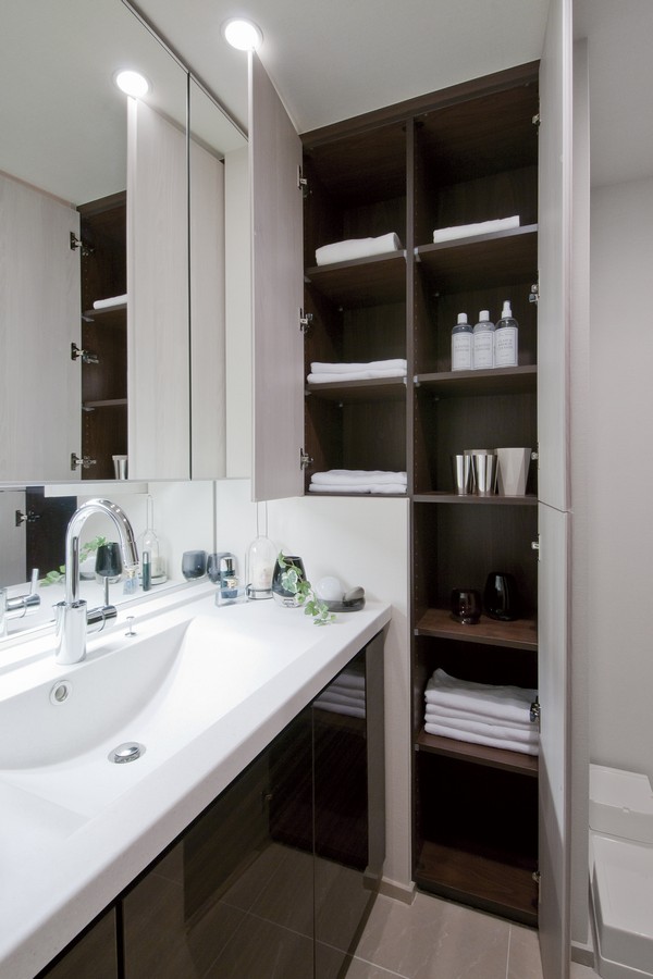 Powder room with three-sided mirror housing and a large linen cabinet has been installed