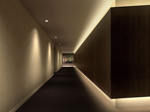 Features of the building.  [Corridor design among full of flavor] Shared hallway is friendly to privacy, It has adopted an inner corridor design. Elevator approach is to suppress the amount of light, such as indirect lighting, Adopt a lighting plan which forms a contrast with the light full of space, such as a light garden or dwelling unit floor. A series of sequence leading to the dwelling unit from the entrance, We have made the accent that was full of flavor. (Elevator approach Rendering)