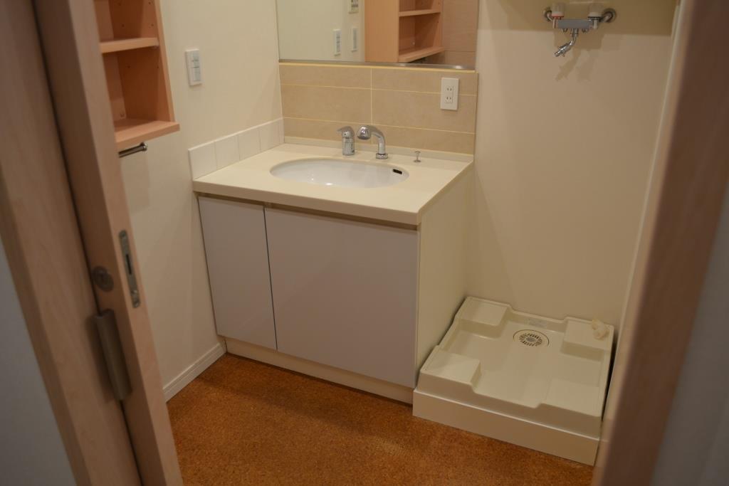 Washroom. There is a washing machine storage and wash basin in the bathroom next to.