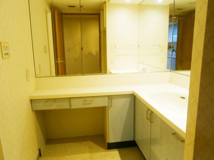 Wash basin, toilet. Clear of the L-shaped dresser, Vanity triple mirror back storage