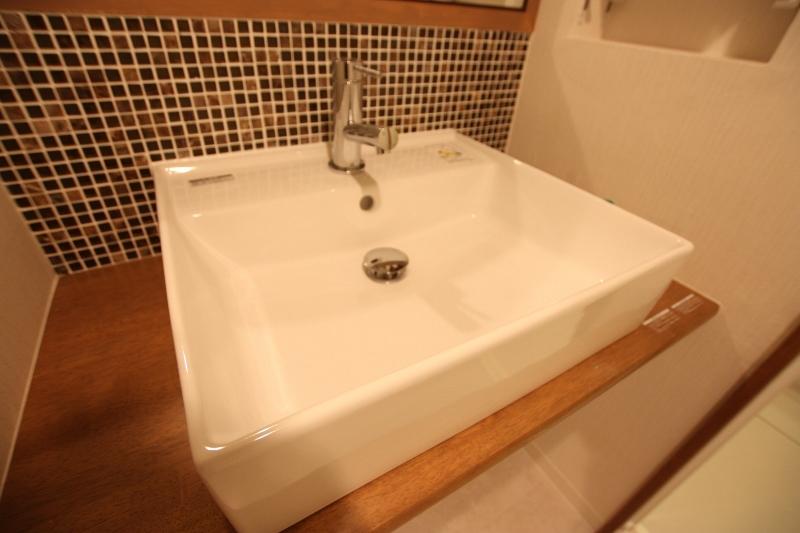 Wash basin, toilet. Wash basin was finished with mosaic tile specification.