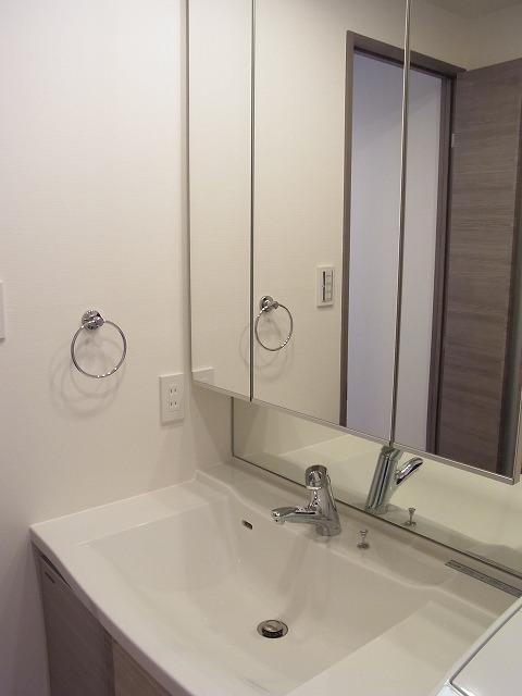 Wash basin, toilet. Wash basin with large three-sided mirror