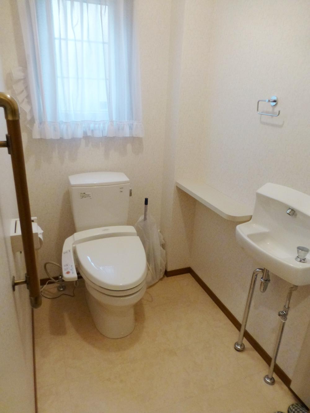 Toilet. It is L-shaped with a handrail to support the Standing sitting. 